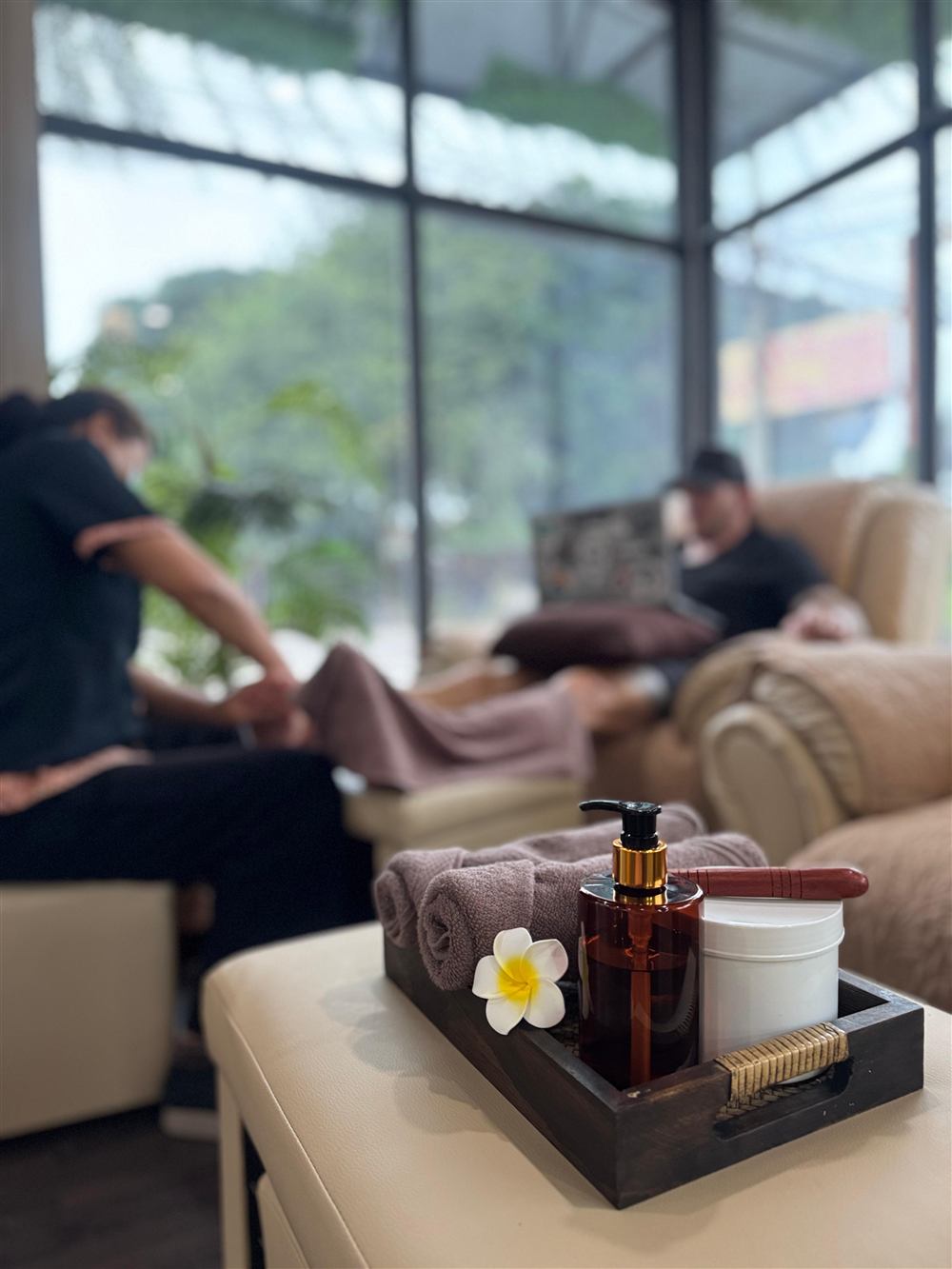 Therapist giving a foot massage in the bright lounge at Outback Massage
