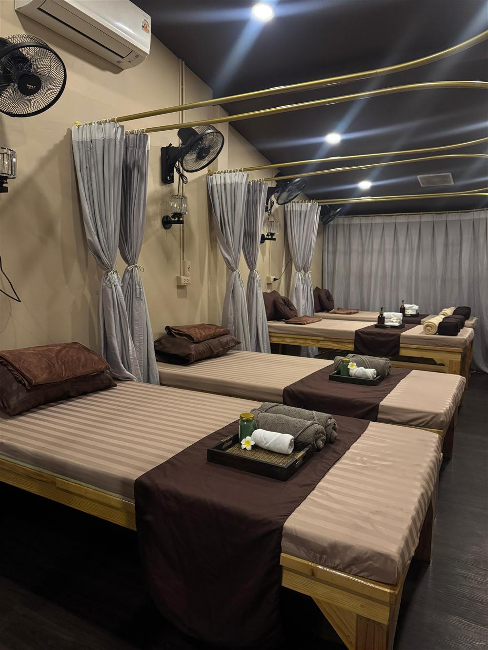 Private curtained Thai massage room with a row of comfortable mats